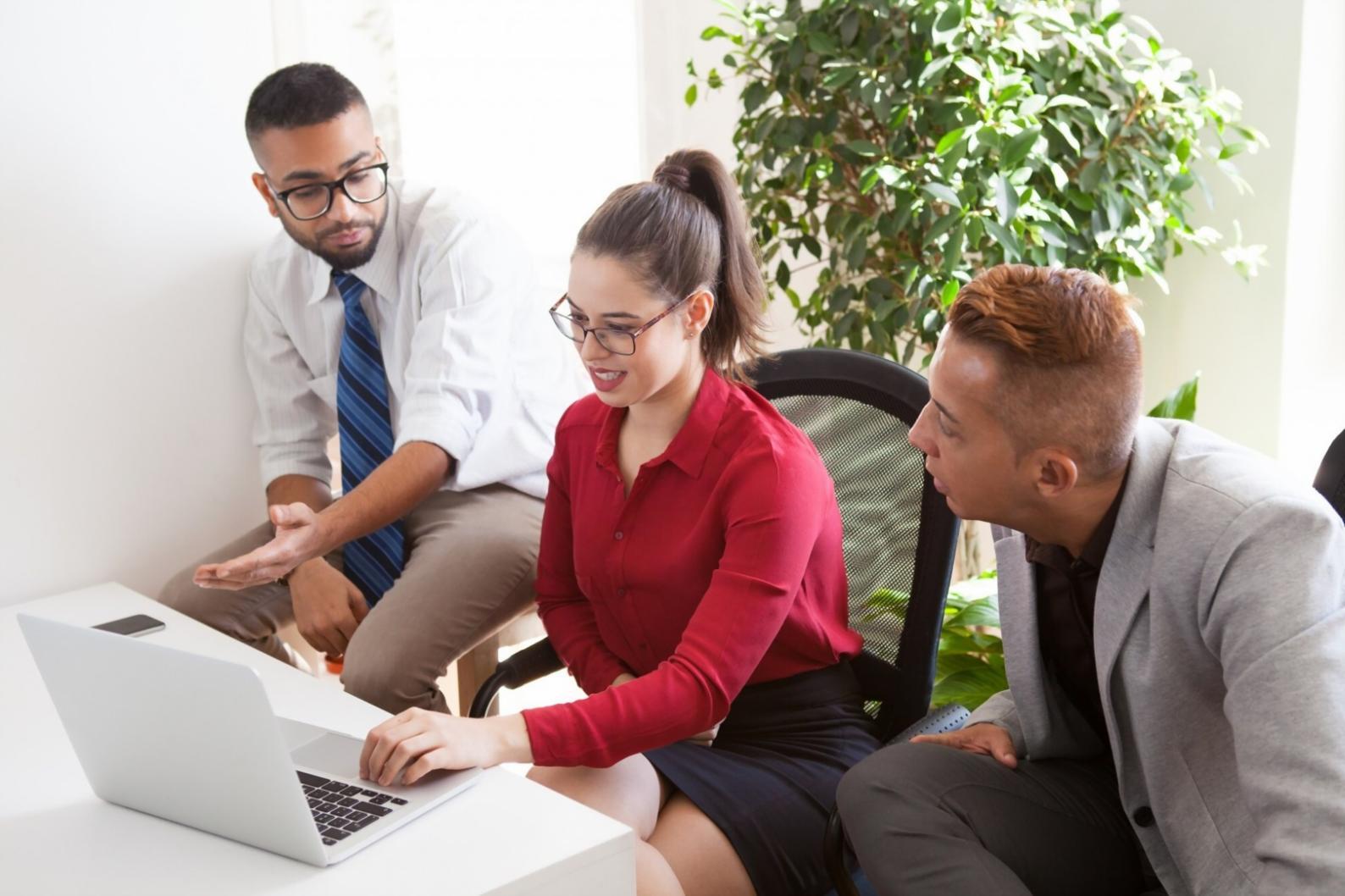 Students collaborating on budget analysis using laptops and spreadsheets